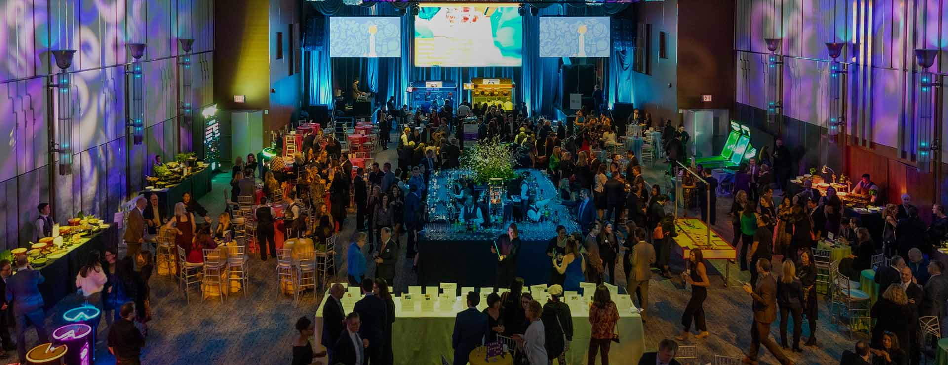 An aerial view of an NYU Langone fundraising event with a crowd of people in a ballroom
