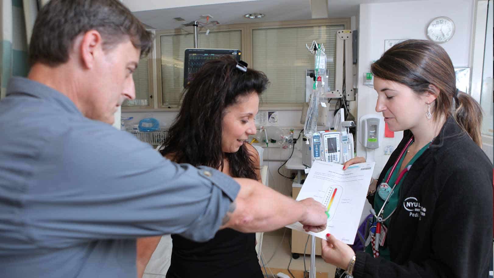Pediatric Patients looking at a chart with their doctor at the Grossman Pediatrics Center