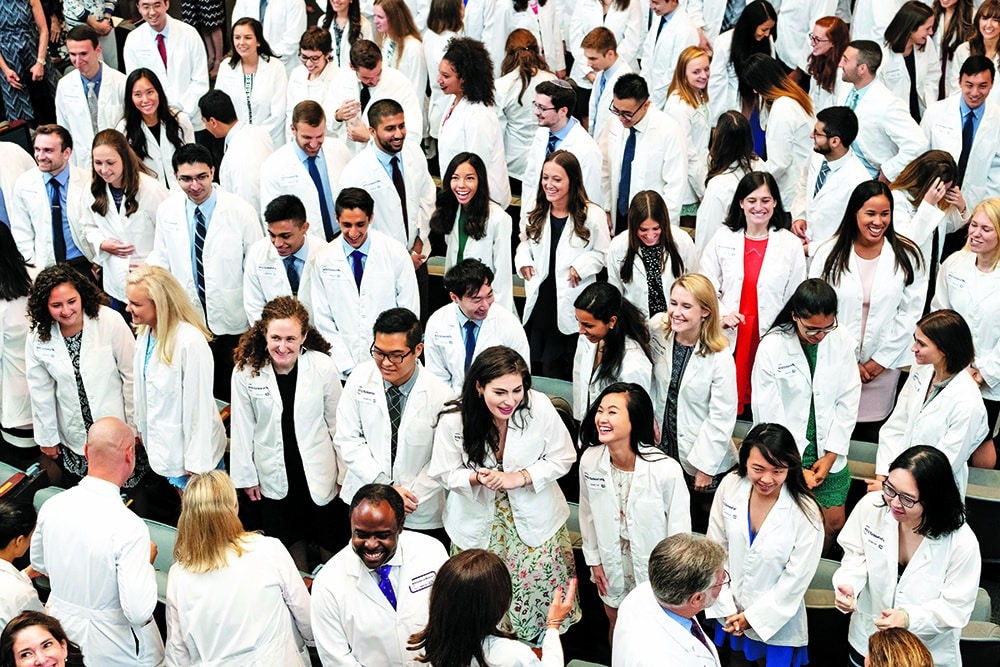 A group of doctors photographed from above; they are standing in their doctor coats